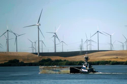 In this Sept. 23, 2013, file photo, a tugboat pushes a barge down the Sacramento River past wind turbines near Rio Vista, Calif. Image credit: AP Photo/Rich Pedroncelli, File