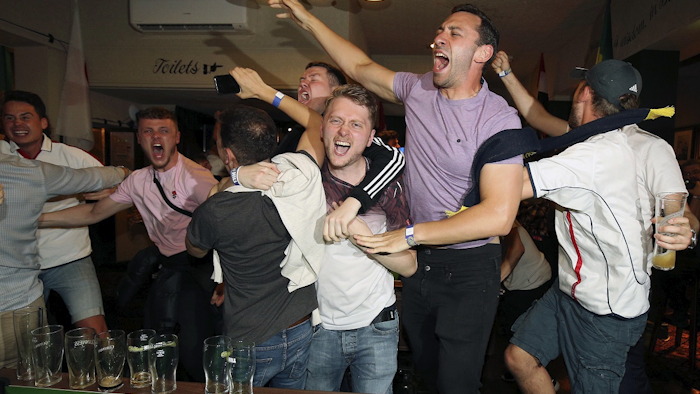 England supporters celebrate Harry Kane's winning goal as fans watch the World Cup soccer match between Tunisia and England at the Lord Raglan Pub in London, Monday, June 18, 2018. Image credit: Nigel French/PA via AP