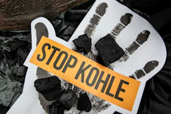 Coal lay on a poster with slogan 'Stop Coal', during demonstration demanding the end of burning coal to produce electricity, in Berlin, Germany, Sunday, June 24, 2018. Image credit: Paul Zinken/dpa via AP