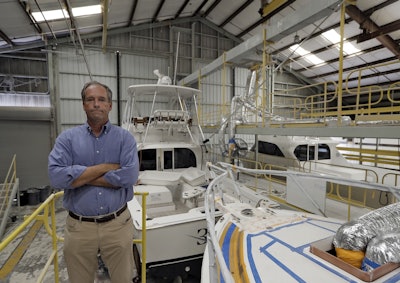 Peter Truslow, Chief Executive Officer for Bertram, a boat building company, poses near three of his custom made boats Friday, June 22, 2018, in Tampa, Fla. Image credit: AP Photo/Chris O'Meara