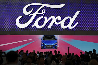 In this file photo taken Wednesday, April 25, 2018, visitors and journalists crowd near a Ford Focus on display at the Ford exhibit during the media day for the China Auto Show in Beijing. Image credit: AP Photo/Andy Wong, File