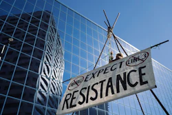 A line 3 oil pipeline opponent named Ben, who requested only his first name be used, hangs from a tripod in the middle of 7th Place in St. Paul, Minn. before a hearing at the Public Utilities Commission in St. Paul, Minn. on Thursday, June 28, 2018. Image credit: Evan Frost/Minnesota Public Radio via AP