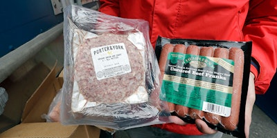 In this May 24, 2018, photo Amazon worker Tony Biallas displays the deal of the day, which included frozen burgers, hot dogs and sausages, that he purchased for himself at an Amazon Treasure Truck in Seattle. The Treasure Truck is a quirky way for the online retailer to connect with shoppers in person, expand its physical presence and promote itself. Amazon has also used the trucks to try to bring people into Whole Foods, the grocery chain it bought last year. The trucks debuted two years ago and now roam nearly dozens of cities in the United States and England. (AP Photo/Elaine Thompson)