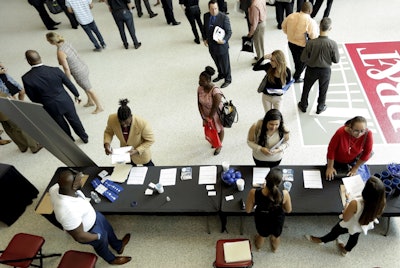 In this Thursday, June 21, 2018 photo, job applicants talk with representatives from Custom Services at a job fair hosted by Job News South Florida, in Sunrise, Fla. Image credit: AP Photo/Lynne Sladky