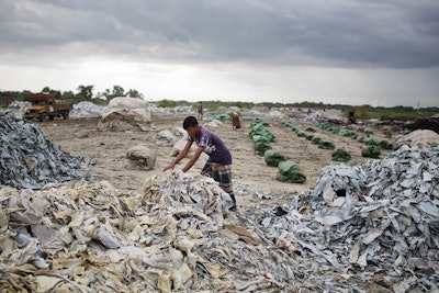 In this Friday, June 29, 2018, photo, a Bangladeshi worker gathers strips of tannery salvaged from waste on the banks of the Daleshwari River in Savar, Bangladesh. Image credit: AP Photo/A.M. Ahad