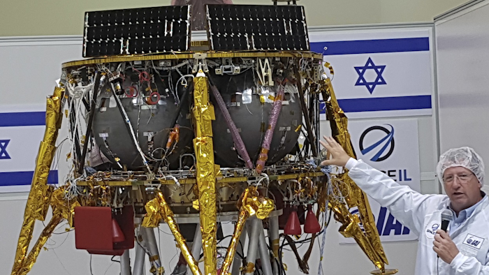 Opher Doron, general manager of Israel Aerospace Industries' space division, speaks beside the SpaceIL lunar module, in a special 'clean room' where the space craft is being developed, during a press tour of their facility near Tel Aviv, Israel, Tuesday, July 10, 2018. Image credit: AP Photo/Ilan Ben Zion