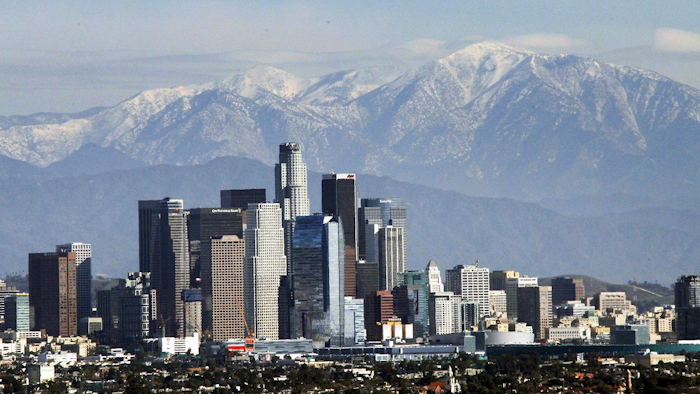 In this Dec. 31, 2014, file photo, the snow-capped San Gabriel Mountains provide a backdrop to the downtown Los Angeles skyline as seen from Kenneth Hahn State Recreation Area in Baldwin Hills. Image credit: AP Photo/Nick Ut, File