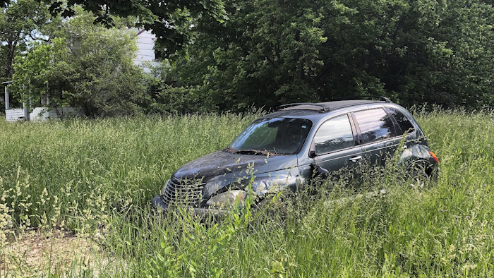 This June 6, 2018 photo shows a vacant house, back left, and abandoned car in Detroit's Brightmoor neighborhood. Image credit: AP Photo/Corey Williams