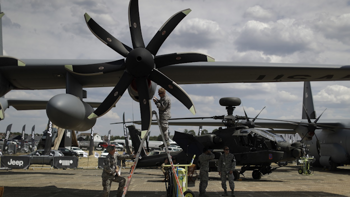 British Prime Minister Theresa May, left, speaks with Airbus CEO Tom Enders, from Germany, backdropped by an Airbus A400M Atlas military transport aircraft at the Farnborough Airshow in Farnborough, England, Monday, July 16, 2018. AP Photo/Matt Dunham