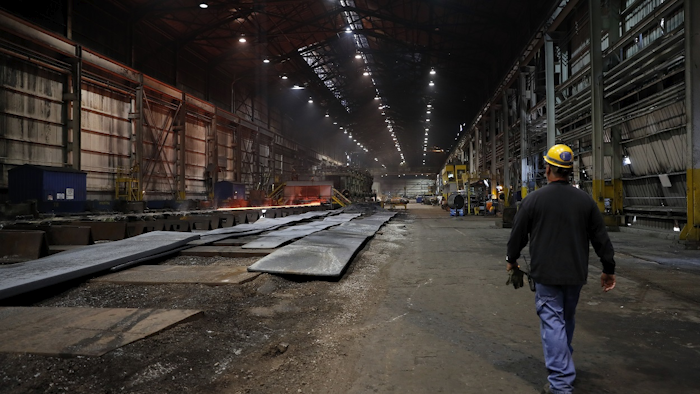 In this June 28, 2018, file photo, a worker walks inside the hot-strip mill at the U.S. Steel Granite City Works facility in Granite City, Ill. Image credit: AP Photo/Jeff Roberson, File
