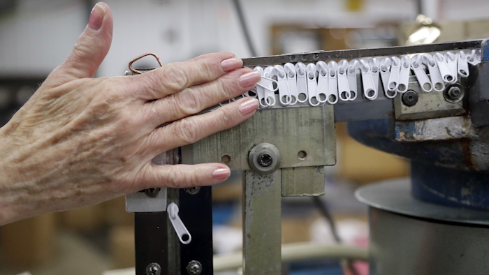 In this May 17, 2018 photo, zipper sliders travel through a machine that places them onto zipper chains at the Dunlap Industries facility in Dunlap, Tenn. Image credit: AP Photo/Mark Humphrey