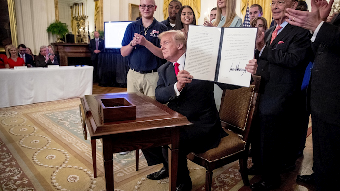 President Donald Trump, accompanied by Ivanka Trump, the daughter of President Donald Trump, second from right, Commerce Secretary Wilbur Ross, right, and workers, holds up an Executive Order that establishes a National Council for the American Worker after signing it during a ceremony in the East Room of the White House, Thursday, July 19, 2018, in Washington. Image credit: AP Photo/Andrew Harnik