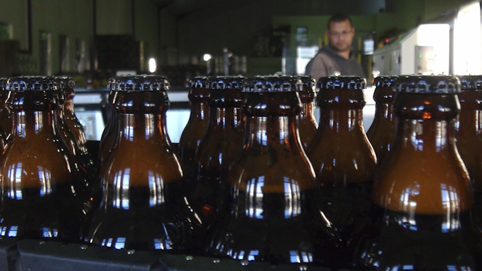 In this June 5, 2018, photo, bottles of freshly bottled beer stand in the Darling Brewery in Darling, South Africa. Image credit: AP Photo/Neil Shaw