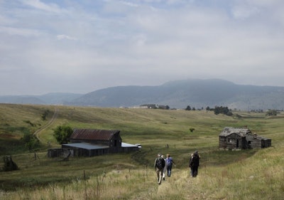 In this Aug. 11, 2017 file photo, visitors approach a former ranch house and barn during a guided hike on the Rocky Flats National Wildlife Refuge near Denver, land that used to be a buffer zone around a nuclear weapons plant. Environmentalists and community activists are trying to stop the refuge from opening to the public this summer, claiming the U.S. Fish and Wildlife Service did not adequately study the safety of the site. (AP Photo/Dan Elliott)