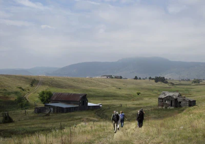 In this Aug. 11, 2017 file photo, visitors approach a former ranch house and barn during a guided hike on the Rocky Flats National Wildlife Refuge near Denver, land that used to be a buffer zone around a nuclear weapons plant. Environmentalists and community activists are trying to stop the refuge from opening to the public this summer, claiming the U.S. Fish and Wildlife Service did not adequately study the safety of the site. (AP Photo/Dan Elliott)