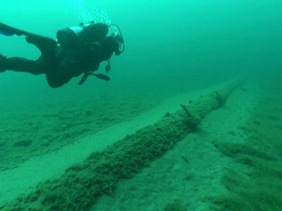 A diver working on behalf of the nonprofit National Wildlife Federation inspects the Line 5 oil pipelines at the lake bottom in the Straits of Mackinac during a July 2013 dive. (National Wildlife Federation)