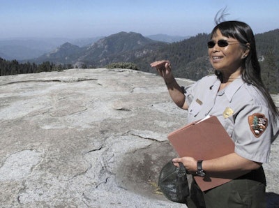 In this May 11, 2012, file photo, Sequoia National Park air resource specialist Annie Esperanza explains how ozone diminishes the view from Beetle Rock in Sequoia National Park, Calif. A new study concludes visitors may be steering clear of some U.S. national parks or cutting their visits short because of pollution. (AP Photo/Tracie Cone)