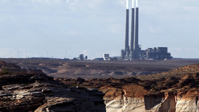 This Sept. 4, 2011 file photo shows the main plant facility at the Navajo Generating Station northeast of Grand Canyon National Park as seen from Lake Powell in Page, Ariz. A new study concludes visitors may be steering clear of some U.S. national parks or cutting their visits short because of pollution. (AP Photo/Ross D. Franklin)