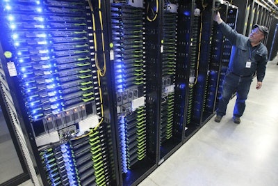 In this Oct. 15, 2013, file photo, Chuck Goolsbee, site director for Facebook's Prineville data centers, shows the computer servers that store users' photos and other data, at the Facebook site in Prineville, Ore. Facebook and Pacific Power are teaming up to construct solar projects that will produce enough power to offset what the social media giant consumes at its data centers in Prineville. The companies along with Oregon Gov. Kate Brown announced the deal Wednesday, July 18, 2018. (Andy Tullis/The Bulletin via AP)