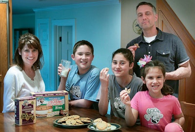 In this April 28, 2011 photo, Paula, left, and husband Chris White, standing at right, pose with their children and some of their 600 lb Gorillas frozen ice cream sandwiches and cookies in Duxbury, Mass. The 600 lb Gorillas company, which the couple founded, filed suit against ice cream supplier Mister Cookie Face, claiming millions of dollars in lost profits because the supplier changed the ice cream recipe contrary to the agreement. The case will be heard in Boston federal court in July 2018. (Gary Higgins/The Patriot Ledger via AP)