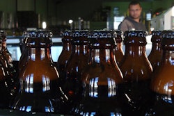 In this June 5, 2018, photo, bottles of freshly bottled beer stand in the Darling Brewery in Darling, South Africa. The South African brewery appears to be the first in Africa to go carbon-neutral as more businesses across the continent adjust to climate change, and as consumers become more careful about the products they buy. (AP Photo/Neil Shaw)