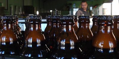 In this June 5, 2018, photo, bottles of freshly bottled beer stand in the Darling Brewery in Darling, South Africa. The South African brewery appears to be the first in Africa to go carbon-neutral as more businesses across the continent adjust to climate change, and as consumers become more careful about the products they buy. (AP Photo/Neil Shaw)