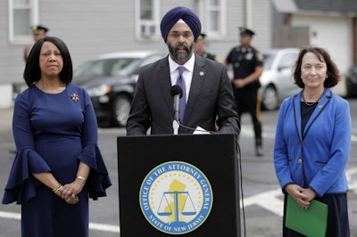 New Jersey Attorney General Gurbir Grewal, center, stands with Lt. Gov. Sheila Oliver, left, and state Environmental Protection Commissioner Catherine McCabe during a news conference announcing pollution lawsuits filed by the state, Wednesday, Aug. 1, 2018, in Newark, N.J. Grewal said it's the largest single-day action the state has taken in at least a decade and the first new natural resources damages case since 2008. He said he didn't have an estimate for what the state might recover financially but said the cases could take a long time to prosecute. The cases include two sites in Newark, two in Woodbridge and one each in Atlantic City and Warren County. (AP Photo/Julio Cortez)