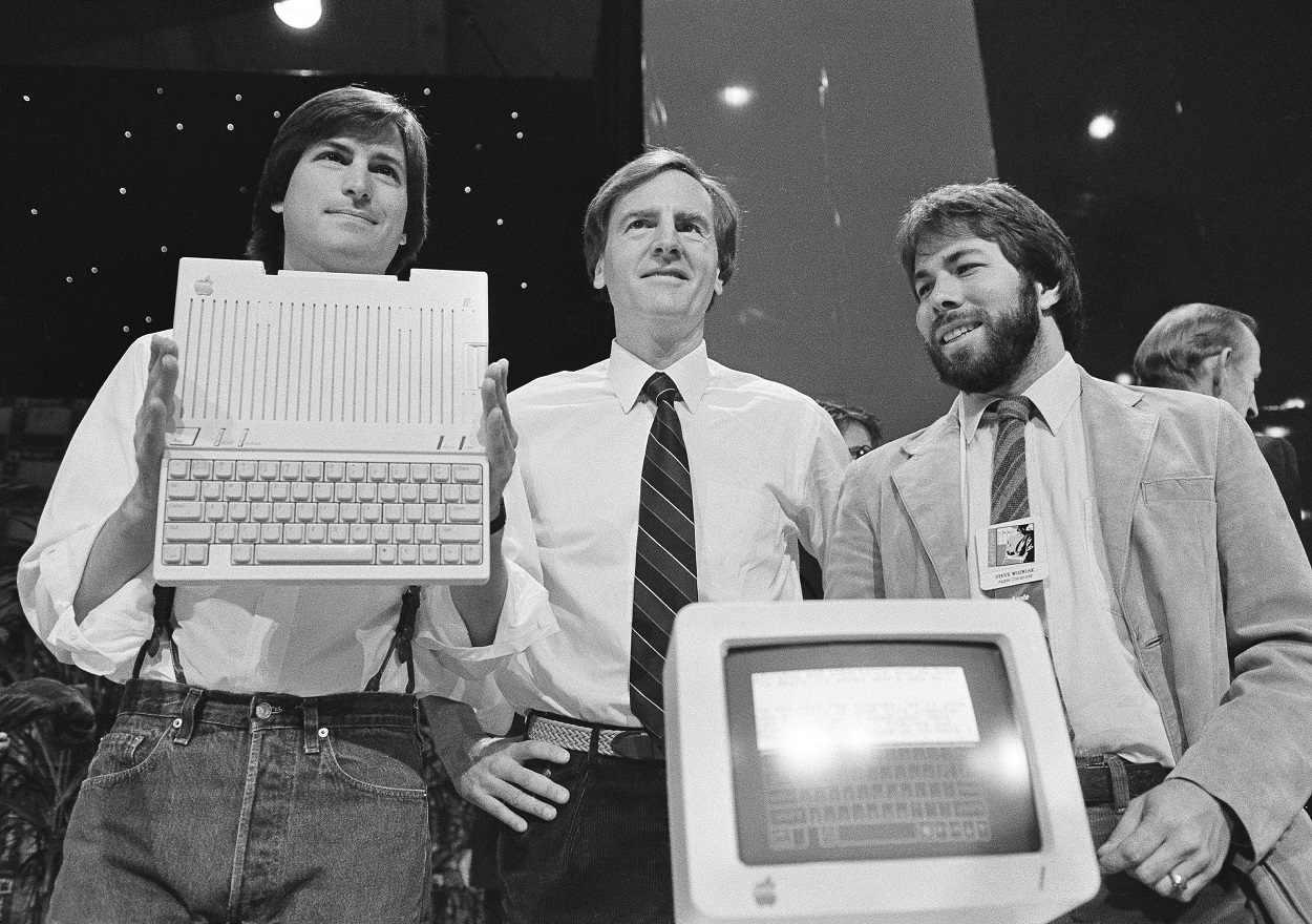 In this April 24, 1984 file photo, Steve Jobs, left, chairman of Apple Computers, John Sculley, center, president and CEO, and Steve Wozniak, co-founder of Apple, unveil the new Apple IIc computer in San Francisco, Calif. Image credit: AP Photo/Sal Veder, File