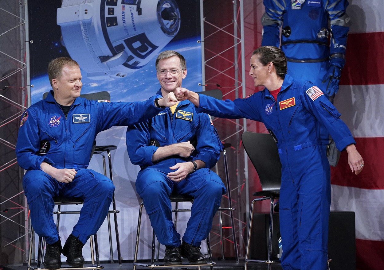 Astronauts Nicole Mann, right, and Eric Boe, left, bump fists in front of Christopher Ferguson after being introduced during a NASA event to announce the astronauts assigned to crew the first flight tests and missions of the Boeing CST-100 Starliner and SpaceX Crew Dragon, Friday, Aug. 3, 2018, in Houston. Image credit: AP Photo/David J. Phillip