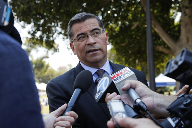 California Attorney General Xavier Becerra talks to reporters after a news conference at University of California, Los Angeles Thursday, Aug. 2, 2018. Becerra spoke about his efforts to fight the Trump administration's proposal to weaken car efficiency fuel standards. (AP Photo/Jae C. Hong)