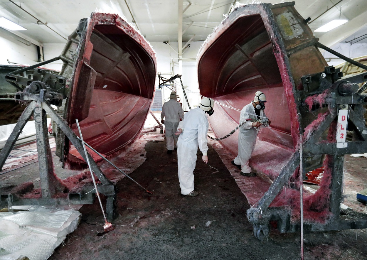 In this July 11, 2018 file photo, workers put finishing touches on boat exteriors at Regal Marine Industries in Orlando, Fla. Image credit: AP Photo/John Raoux, File