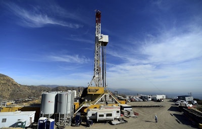 In this Dec. 9, 2015, file pool photo, crews work on a relief well at the Aliso Canyon facility above the Porter Ranch area of Los Angeles. Southern California Gas Co. said announced Wednesday, Aug. 8, 2018 that a nearly $120 million settlement has been reached in litigation stemming from a leak at a Los Angeles storage field where a massive methane release forced thousands from their homes. (Dean Musgrove /Los Angeles Daily News via AP)
