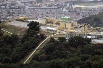 This Jan. 12, 2017 file photo shows gas gathering plant on a hilltop at the Southern California Gas Company's Aliso Canyon storage facility near the Porter Ranch neighborhood of Los Angeles. A tentative settlement has been reached in litigation stemming from a leak at a Los Angeles storage field where a massive methane release forced thousands from their homes three years ago. (AP Photo/Jae C. Hong)