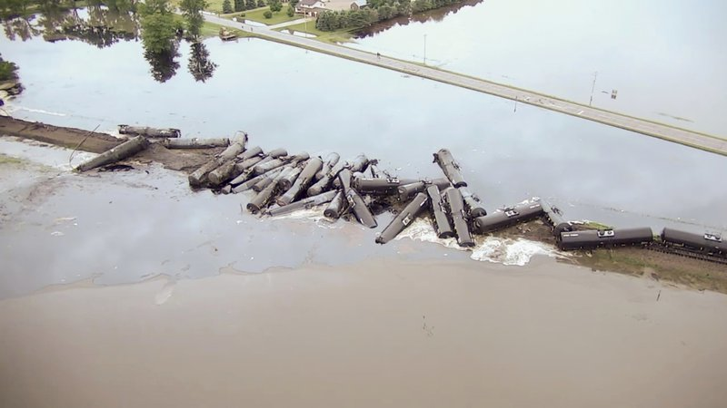 In this Friday, June 22, 2018, file aerial drone image taken from video and provided by the Sioux County Sheriff's Office, tanker cars carrying crude oil are shown derailed about a mile south of Doon, Iowa. BNSF Railway acknowledged Friday, Aug. 10, 2018, that flooding played a role in a derailment that loosed thousands of gallons of oil into northwest Iowa floodwaters. The National Transportation Safety Board report cited heavy rainfall in the area 48 hours before the derailment. (Sioux County Sheriff's Office via AP)