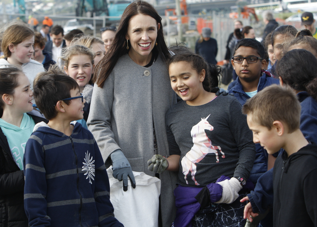 New Zealand Prime Minister Jacinda Ardern leads a group of schoolchildren on a beach cleanup Friday, Aug. 10, 2018, at Lyall Bay in Wellington, New Zealand. Ardern announced Friday that New Zealand plans to ban disposable plastic shopping bags by next July as the nation tries to live up to its clean-and-green image. (AP Photo/Nick Perry)
