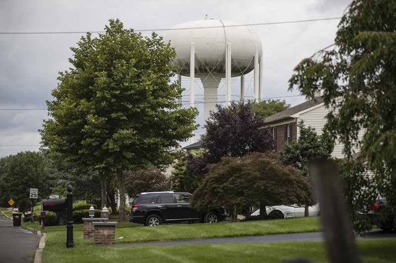 In this Aug. 1, 2018 photo, a water tower stands above a residential neighborhood in Horsham, Pa. In Horsham and surrounding towns in eastern Pennsylvania, and at other sites around the United States, the foams once used routinely in firefighting training at military bases contained per-and polyfluoroakyl substances, or PFAS. EPA testing between 2013 and 2015 found significant amounts of PFAS in public water supplies in 33 U.S. states. (AP Photo, Matt Rourke)