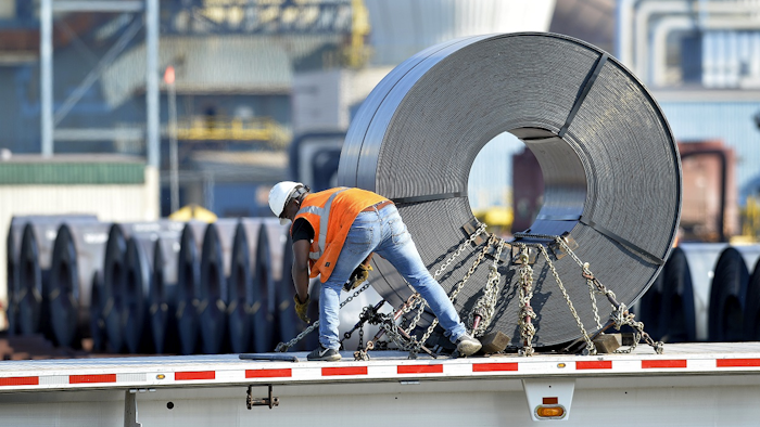 In this July 25, 2018, photo a truck driver chains down a roll of steel to his flatbed at the NUCOR Steel Gallatin plant in Ghent, Ky. Image credit: AP Photo/Timothy D. Easley