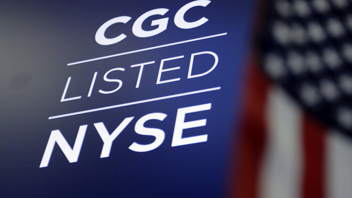 In this May 31, 2018, file photo the logo for Canada's Canopy Growth Corp. appears on a screen above a trading post on the floor of the New York Stock Exchange. Image credit: AP Photo/Richard Drew, File