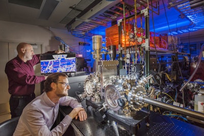 Sandia National Laboratories researchers Michael Chandross, left, and Nic Argibay show a computer simulation used to predict the unprecedented wear resistance of their platinum-gold alloy, and an environmental tribometer used to demonstrate it. Image credit: Photo by Randy Montoya