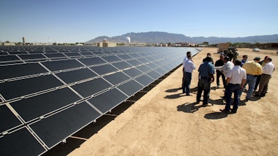 This April 20, 2011 file photo officials with Arizona-based First Solar and Public Service Company of New Mexico gather after the dedication of the utility's new 2-megawatt photovoltaic solar array in Albuquerque, N.M. Image credit: AP Photo/Susan Montoya Bryan,File