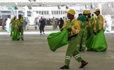 Sanitation workers collect litter during the annual hajj pilgrimage in Mecca on August 22, 2018. (AFP/Ahmad Al-Rubaye)