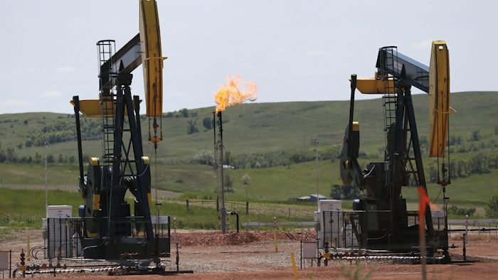 In this June 12, 2014 file photo, natural gas is burned off near pumps in Watford City, N.D. Image credit: AP Photo/Charles Rex Arbogast, File