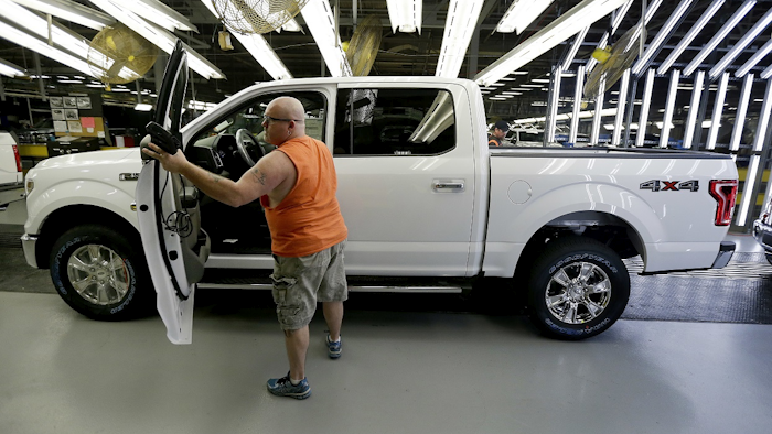 In this March 13, 2015, file photo, a worker inspects a new 2015 aluminum-alloy body Ford F-150 truck at the company's Kansas City Assembly Plant in Claycomo, Mo. Image credit: AP Photo/Charlie Riedel, File