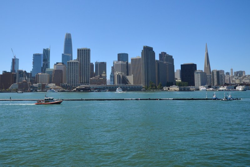 The Ocean Cleanup’s first buoyant trash-collecting device is seen in front of the San Francisco skyline en route to the Pacific Ocean on Saturday, Sept. 8, 2018. Once deployed, the boom will form a U-shaped barrier to trap plastic and trash that currently makes up the 'Great Pacific Garbage Patch.' (AP Photo/Lorin Eleni Gill)