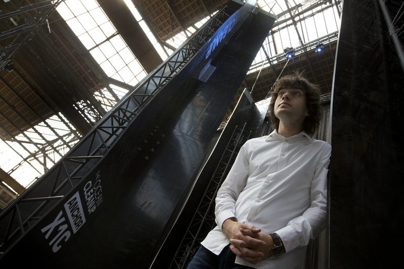 In this May 11, 2017, file photo, Dutch innovator Boyan Slat poses for a portrait next to the anchors of his plastic collecting system, suspended from the roof of a building in Utrecht, Netherlands. Engineers will deploy a trash collection device to corral plastic litter floating between California and Hawaii in an attempt to clean up the world's largest garbage patch in the heart of the Pacific Ocean. The 2,000-foot (600-meter) long floating boom will be towed Saturday, Sept. 8, 2018, from San Francisco to the Great Pacific Garbage Patch, an island of trash twice the size of Texas. The system was created by The Ocean Cleanup, an organization founded by Slat. (AP Photo/Peter Dejong)