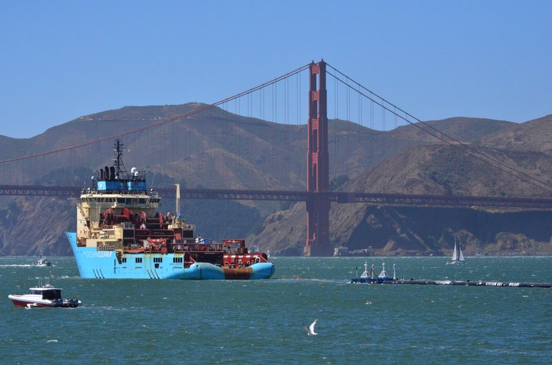 A ship tows The Ocean Cleanup’s first buoyant trash-collecting device toward the Golden Gate Bridge in San Francisco en route to the Pacific Ocean on Saturday, Sept. 8, 2018. Once deployed, the boom will form a U-shaped barrier to trap plastic and trash that currently makes up the 'Great Pacific Garbage Patch.' (AP Photo/Lorin Eleni Gill)