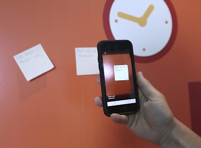 Hector Minto, a Senior Technology accessibility evangelist at Microsoft, demonstrates an app that can audibly describe a handwritten note during an interview with The Associated Press, at Microsoft offices in London, Friday, July 27, 2018. Improvements in artificial intelligence, combined with the decreasing cost of hardware, are making it possible for inventors to develop new products without the need for the deep pockets of governments or big corporations. With the help of 3D printers and the increased processing power of home computers, they are creating devices designed for people with motor, vision, hearing and cognitive impairments. (AP Photo/Robert Stevens)