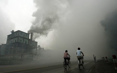 This photo taken on July 18, 2006 shows cyclists passing through thick pollution from a factory in Yutian, 100km east of Beijing in China's northwest Hebei province. Surging levels of carbon dioxide sent greenhouse gases in the atmosphere to a new record in 2013, while oceans, which absorb the emissions, have become more acidic than ever, the UN said on September 9, 2014. (AFP Photo/Peter Parks)