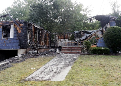 The house owned by Lawrence Police Officer Ivan Soto sits nearly burned to the ground on Jefferson Street, in Lawrence, Mass., Friday, Sept. 14, 2018. It was one of multiple houses that went up in flames on Thursday afternoon after gas explosions and fires triggered by a problem with a gas line that feeds homes in several communities north of Boston. After rushing home to check on his family and warn his neighbors to evacuate, Soto went back on patrol while his house was burning down. (AP Photo/Mary Schwalm)