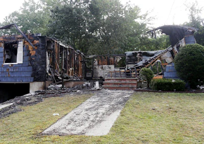 The house owned by Lawrence Police Officer Ivan Soto sits nearly burned to the ground on Jefferson Street, in Lawrence, Mass., Friday, Sept. 14, 2018. It was one of multiple houses that went up in flames on Thursday afternoon after gas explosions and fires triggered by a problem with a gas line that feeds homes in several communities north of Boston. After rushing home to check on his family and warn his neighbors to evacuate, Soto went back on patrol while his house was burning down. (AP Photo/Mary Schwalm)